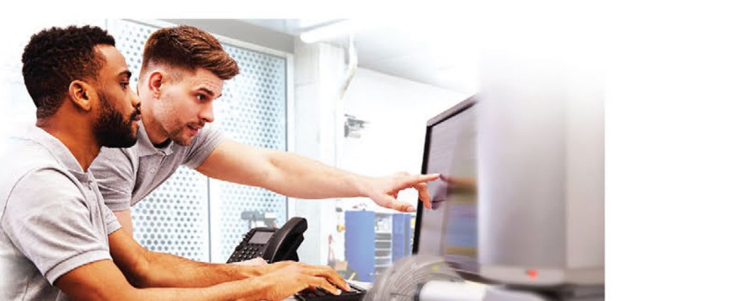 Dos especialistas revisando resultados de inspección en la computadora